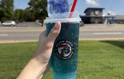 Blue 7 Brew Doh squishy and 7 Energy drink in front of 7 Brew building